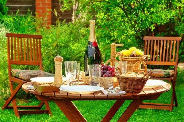 Обеденный стол на открытом воздухе с бутылкой вина на заднем дворе — стоковое фото