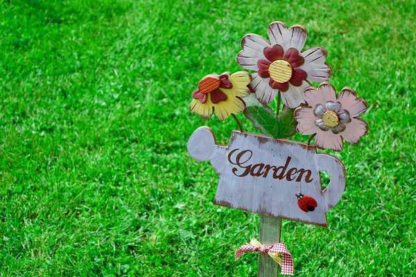 Jardim de sinal na placa de madeira e gramado no fundo — Fotografia de Stock