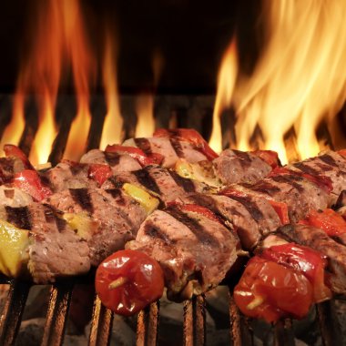 Homemade Kebabs On The BBQ Flaming Charcoal Grill clipart