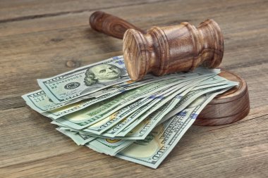 Judges or Auctioneers Gavel And Money Stack On Wooden Background clipart