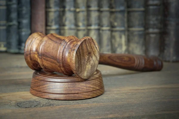 Veilingmeester of rechters hamer onder oude boeken op houten bankje — Stockfoto