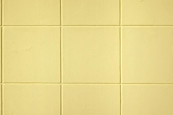 Moderne gelbe Betonwand mit dekorativem quadratischen Muster — Stockfoto