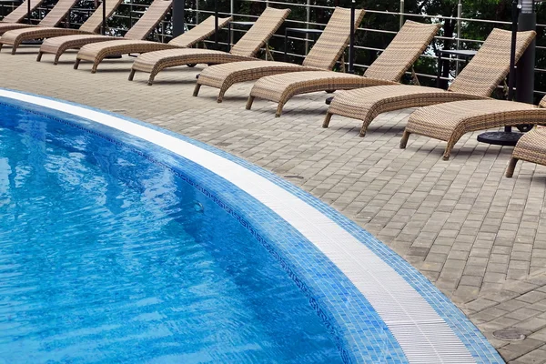 Hotel Poolside Tumbonas vacías de ratán cerca de la encuesta de natación —  Fotos de Stock