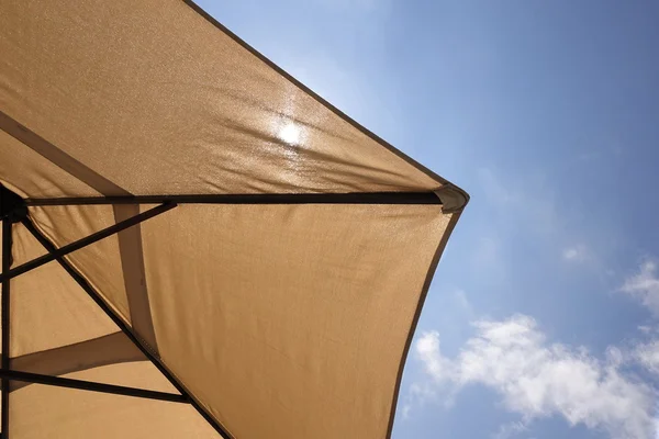 Vista inferior del paraguas de la playa y la luz del sol a través de ella — Foto de Stock