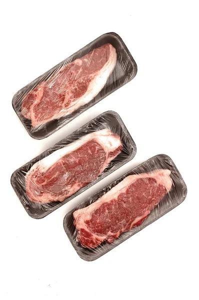 Bifes Carne Striploin Close Bandeja Espuma Com Filme Embrulho Plástico — Fotografia de Stock