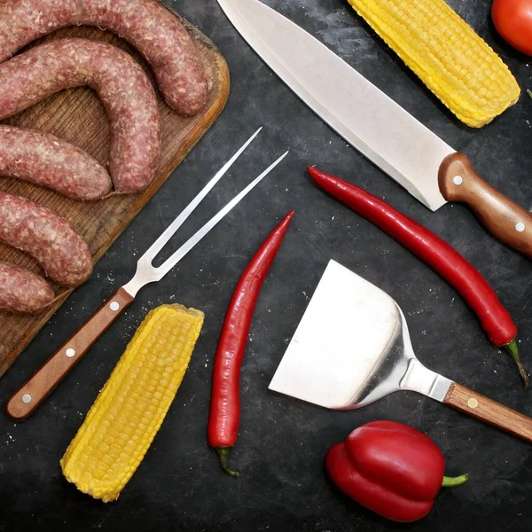 Worstjes Oude Houten Snijplank Groenten Grillgereedschap Zwarte Tafelachtergrond Bovenaanzicht Rauwe — Stockfoto