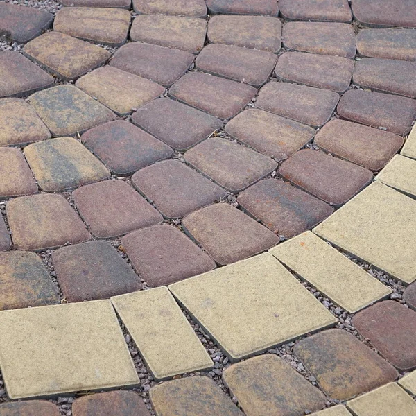 円形の装飾的な舗装 屋外ラウンドパティオ舗装 コンクリート色の石畳でパティオを舗装 庭の造園 装飾的な裏庭のタイル張りの歩道 モザイク石造背景 — ストック写真