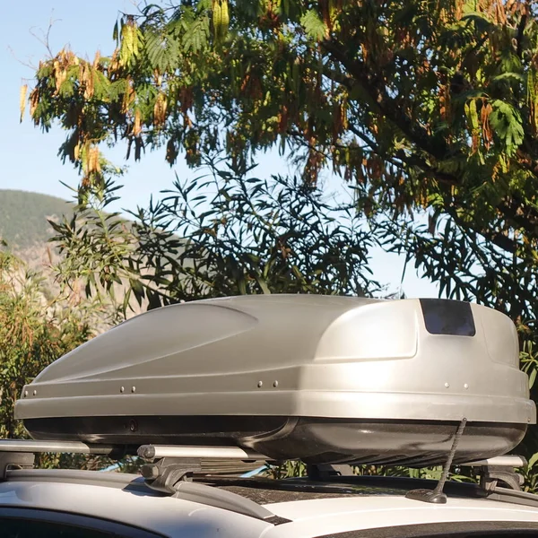 Car Trunk Box On Roof. 4WD Car With Luggage Box On Rooftop Fastening To The Rack System. Closeup View Of Car Roof Box On Rooftop. Travel And Trip Auto Tourism Landscape With Mountain And Sea Beach.