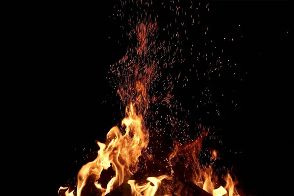 炎と黒の背景に隔離された火花の炎 概要炎の背景 魔法の火の壁紙 フライング スパークス背景 クローズアップ ビュー 夜になると炎が燃え上がる エネルギーコンセプト — ストック写真
