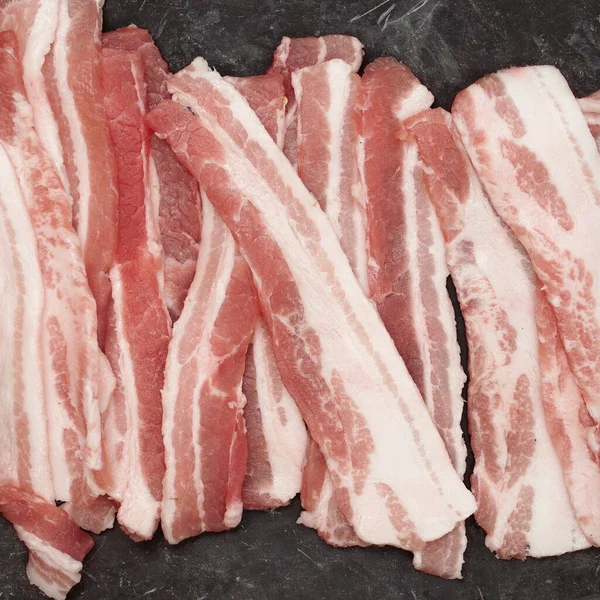 Kallskuren Bacon Svart Bord Grunge Bakgrund Overhead View Streaky Färsk — Stockfoto