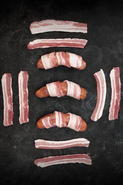 Korv Insvept Bacon Svart Bakgrund Julgrisar Filtar Råkorv Naturligt Hölje — Stockfoto