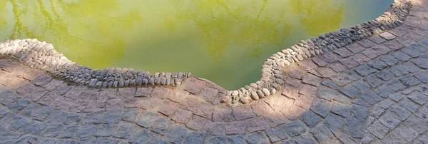 Staw Ogrodzie Zieloną Wodą Okresie Letnim Utwardzona Ścieżka Naturalnego Kamienia — Zdjęcie stockowe