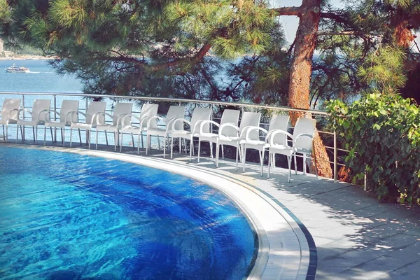 Empty Swimming Pool On Terrace In The Mountains Park With High Above Sea View. Outdoor Hotel Or Villa Or Apartments Terrace With Outside Pool And Twelve White Chairs