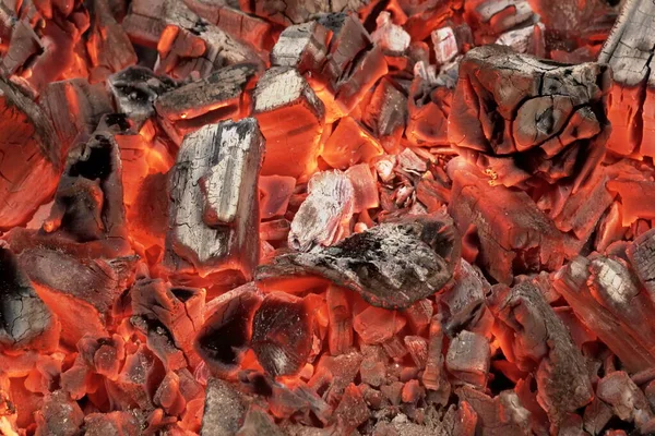 烧烤烧烤坑与发光和燃烧热焦炭 烤肉中的热焦炭 带有火焰背景结构 在黑色背景上孤立的炉膛孔中燃烧焦炭 — 图库照片