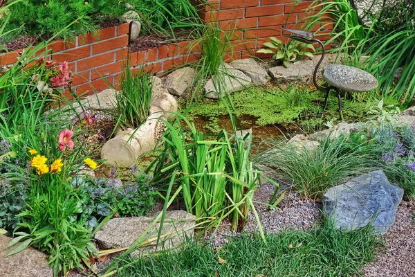 Landschaftsgarten Hinterhof Mit Gestalteten Landschaftsgestaltungselementen Garten Mit Dekorativer Ziegelmauer Kleinem lizenzfreie Stockfotos