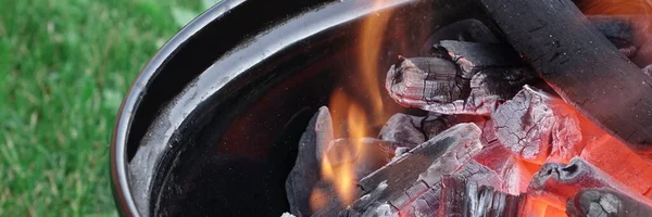 水壶烧烤坑与燃烧焦炭 烤肉热烤架关闭 烧烤水壶烤在夏天的后院准备烘烤烹调食物 图库照片