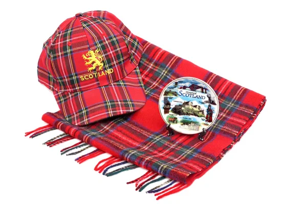 Gorra de tartán rojo escocés, bufandas de tartán y plato de recuerdo — Foto de Stock