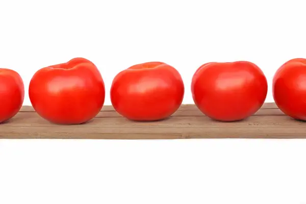 Cinco tomates sobre tabla de madera — Foto de Stock