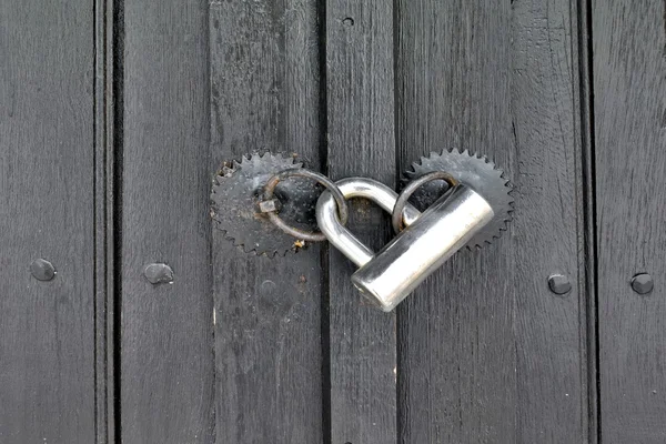 Modern padlock on textured black wooden door — Stock Photo, Image