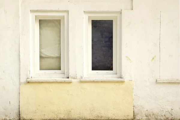 Two Old Closed Windows  in the Old White Concrete Wall