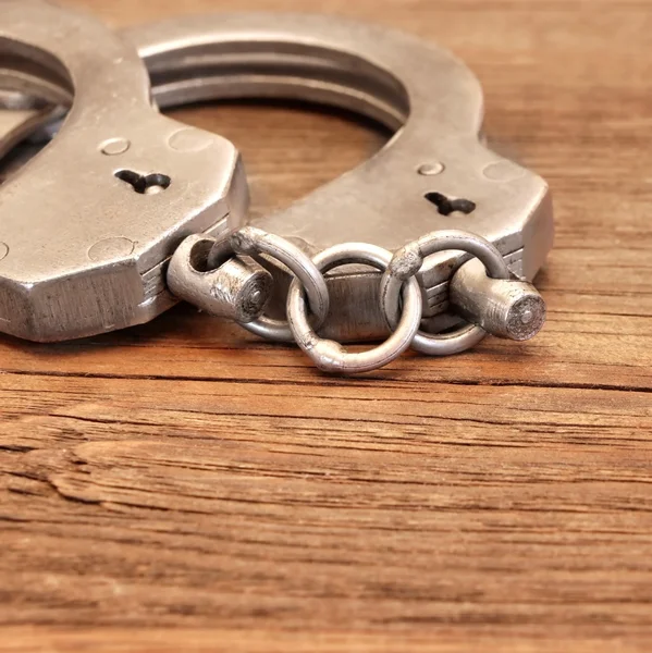 Steel Handcuffs on Wooden Table — Stock Photo, Image