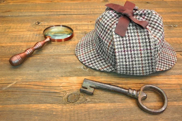 Sherlock Holmes Cap známé jako Deerstalker, staré klíče a Lupa — Stock fotografie