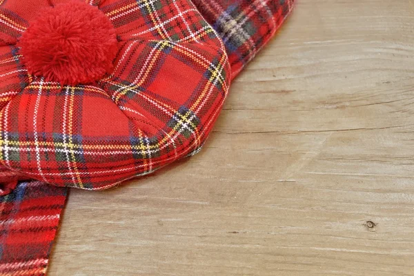 Bonnet Tartan vermelho escocês tradicional e cachecol na placa de madeira — Fotografia de Stock