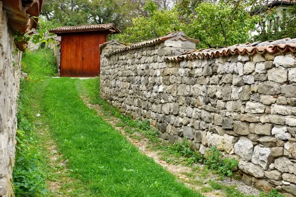 Vecchio cancello in legno e recinzione in pietra — Foto Stock