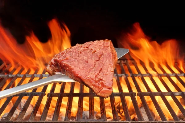 Bife cru na lâmina sobre uma churrasqueira quente — Fotografia de Stock