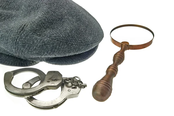 Warm Cap with Earflaps, Magnifying Glass and Handcuffs — Stock Photo, Image