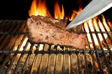 Chef Knife in the Grilled Meat Chop. Flame in Background. clipart