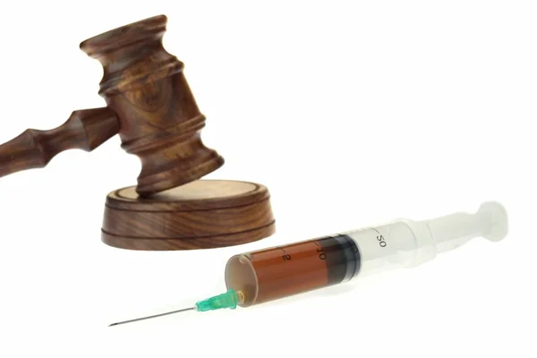 裁判官小槌と分離された茶色の液体を注射器 — ストック写真