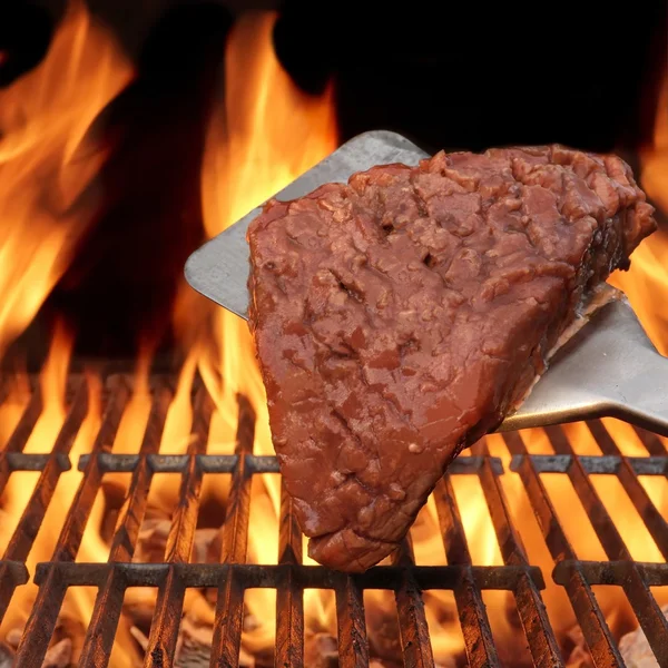 Bife grelhado de chama na churrasqueira — Fotografia de Stock