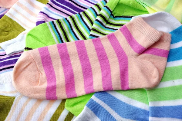 Birçok çift renkli çizgili çorap üzerine beyaz izole yığını — Stok fotoğraf