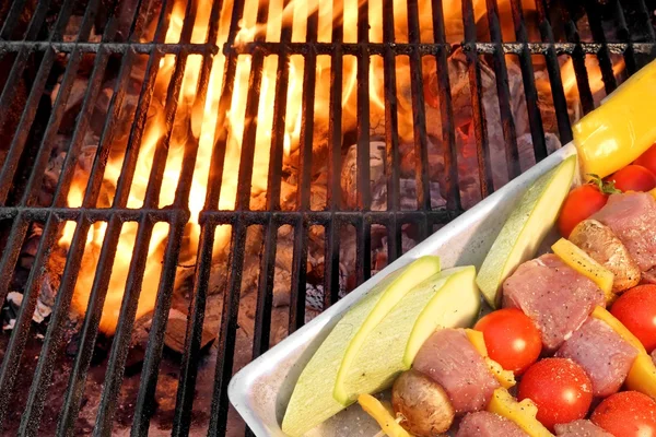 Nicht gegarte Kabobs auf dem flammenden Grill in Großaufnahme — Stockfoto