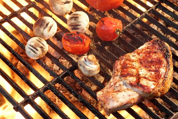 Барбекю жареный стейк, помидоры и грибы на горячем гриле — стоковое фото