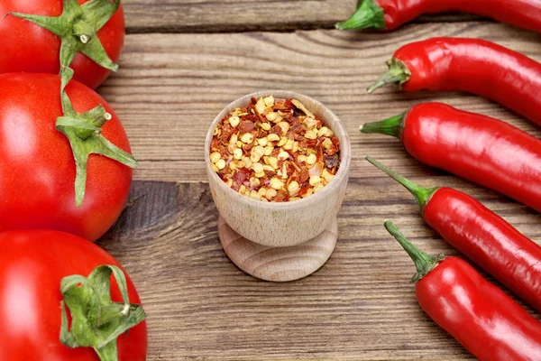 Papryka, pomidory i mielona papryka Chili płatków na drewniane Dzik — Zdjęcie stockowe