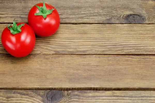 Två mogna tomater på rustik trä bakgrund — Stockfoto