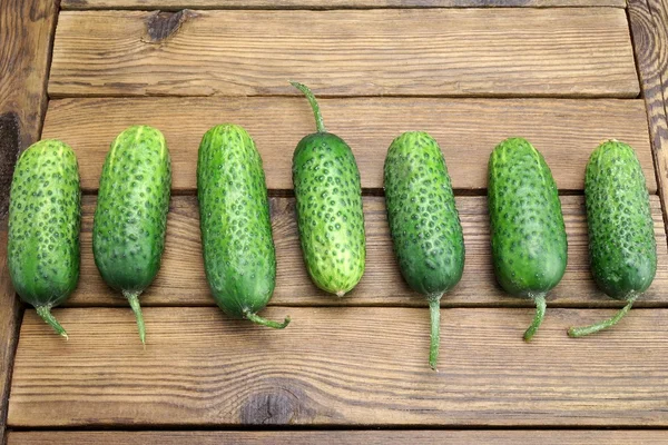 Fresh Seven Cucumbers On The Rough Wood Background — Stock Photo, Image