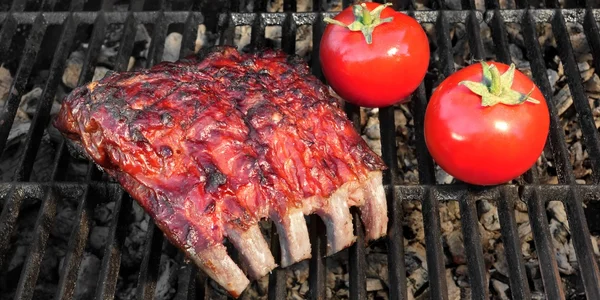 Chutné grilované Barbecue uzená marinovaná vepřová žebírka a rajčaty — Stock fotografie