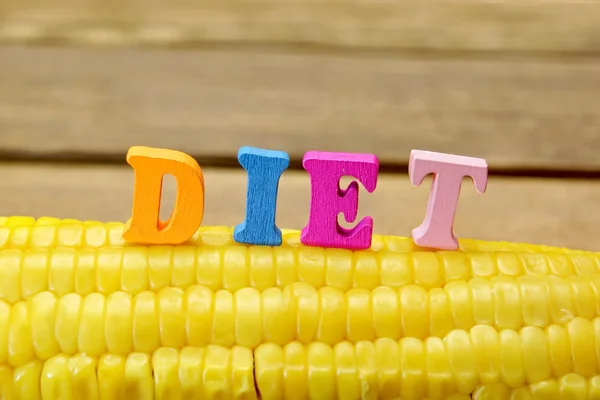 Dieta drewniany znak na zbliżenie świeży kukurydza — Zdjęcie stockowe