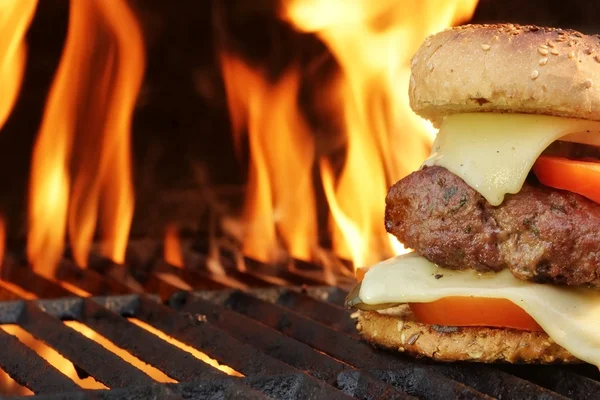 Cheeseburger fatto in casa Primo piano sul barbecue fiammeggiante Backgro — Foto Stock