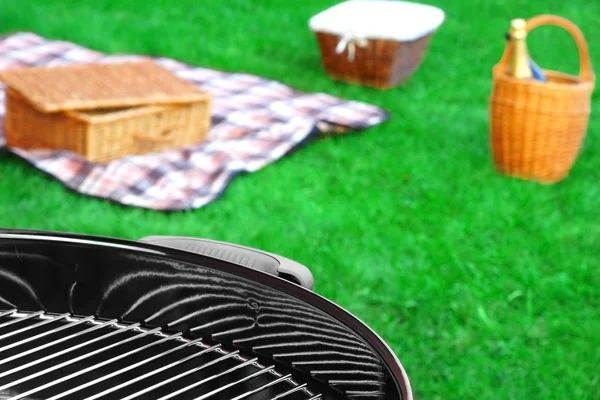 BBQ Grill, piknik koszyk z winem, koc na trawniku — Zdjęcie stockowe