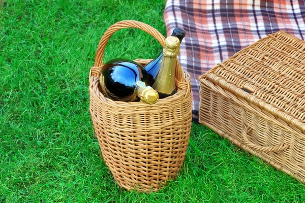 Cesto con vino Champagne, cesto da picnic e coperta — Foto Stock