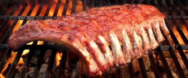 Barbacoa bebé espalda costillas de cerdo en la parrilla de llama caliente — Foto de Stock