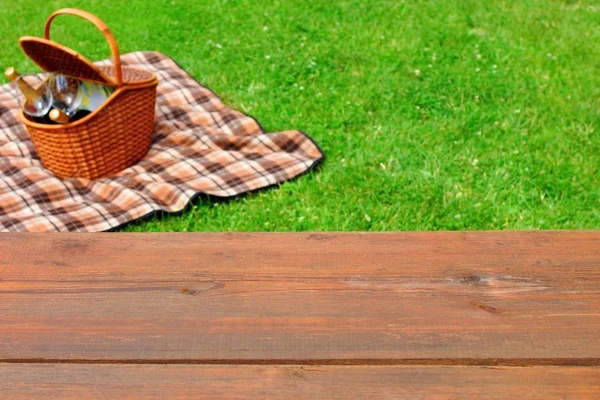 ピクニック卓上のクローズ アップ。ピクニック バスケットや芝生の上の毛布 — ストック写真