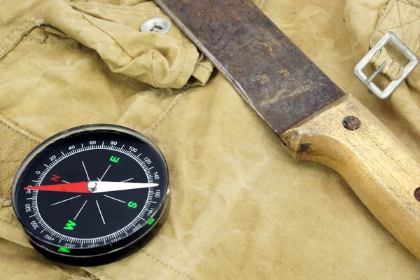 Современный магнитный компас и старый нож на рюкзаке — стоковое фото
