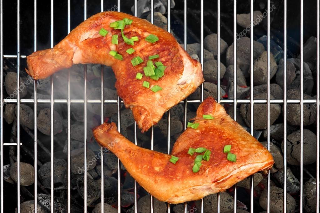 Two BBQ Roast Chicken Quarters On The Hot Charcoal Grill Stock Photo by