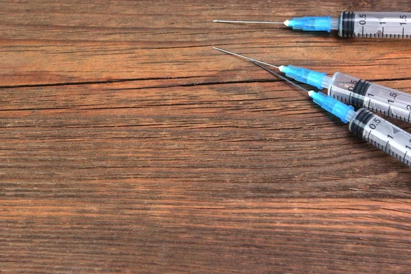 Trei seringi medicale goale pe placa de lemn dur — Fotografie, imagine de stoc