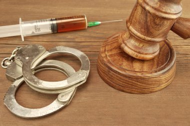 Judges Gavel,  Handcuffs And Syringe On Wood Rough Background clipart